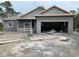 Under construction single-story house with open garage, light grey stucco, and visible materials at 135 Hardee Way, Rotonda West, FL 33947
