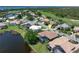 Aerial view of property with lush green landscaping, lake and golf course views from this great community at 13761 Long Lake Ln, Port Charlotte, FL 33953