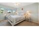Bright bedroom featuring a cozy bed, ceiling fan, and two windows for natural light at 13761 Long Lake Ln, Port Charlotte, FL 33953