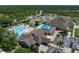Aerial view of community clubhouse featuring a resort-style pool, tennis courts, and beautifully landscaped grounds at 13761 Long Lake Ln, Port Charlotte, FL 33953