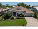 Charming home with a tile roof, manicured landscaping, and a paver driveway, situated on a waterfront lot at 13761 Long Lake Ln, Port Charlotte, FL 33953