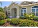 Close up of a charming home's entrance featuring lush landscaping and a tiled walkway at 13761 Long Lake Ln, Port Charlotte, FL 33953