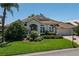 Charming home with lush landscaping, a tile roof, and an attached garage, set in a well-kept neighborhood at 13761 Long Lake Ln, Port Charlotte, FL 33953