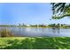 Beautiful lake view with well-maintained homes, lush lawns, and mature trees lining the waterfront under a clear blue sky at 13761 Long Lake Ln, Port Charlotte, FL 33953