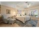 Light-filled main bedroom featuring a tray ceiling, seating area, and large windows at 13761 Long Lake Ln, Port Charlotte, FL 33953