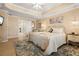 Main bedroom with a tray ceiling, white iron bed frame, and a sitting area at 13761 Long Lake Ln, Port Charlotte, FL 33953
