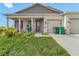Charming home featuring a welcoming porch, red door, and a convenient two-car garage at 15345 Pottstown Ave, Port Charlotte, FL 33981