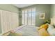 This cozy bedroom features a window with shutters, green walls, and a double closet at 1673 Palace Ct, Punta Gorda, FL 33980