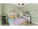 This cozy bedroom features green walls, tile floors, and a comfortable bed with a decorative ceiling fan at 1673 Palace Ct, Punta Gorda, FL 33980