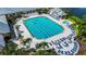 Aerial view of a large swimming pool surrounded by lounge chairs and lush landscaping at 1673 Palace Ct, Punta Gorda, FL 33980