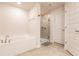 Bright bathroom featuring a tiled floor, glass shower, and relaxing soaking tub at 1690 Yakutat Rd, North Port, FL 34287
