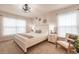 Well-lit bedroom features a neutral color scheme, plush bedding, and a comfortable chair at 1690 Yakutat Rd, North Port, FL 34287