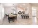 Open floor plan with kitchen bar and dining area, featuring modern lighting and neutral tones at 1690 Yakutat Rd, North Port, FL 34287