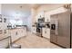 Spacious kitchen with stainless steel appliances, white cabinets, and granite countertops open to the dining area at 1690 Yakutat Rd, North Port, FL 34287