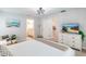 Bright main bedroom featuring a ceiling fan, decor, beach art, and en-suite bathroom at 1690 Yakutat Rd, North Port, FL 34287