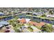Charming canal-front home with a terracotta roof, lush palm trees, and circular driveway at 1796 Boca Raton Ct, Punta Gorda, FL 33950