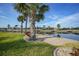 Waterfront backyard with mature palm trees, beautiful landscaping, and a canal view, creating a peaceful retreat at 1796 Boca Raton Ct, Punta Gorda, FL 33950