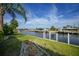 Scenic backyard with well maintained grass, waterfront access, and private docks at 1796 Boca Raton Ct, Punta Gorda, FL 33950