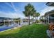 Scenic backyard featuring a canal view, mature landscaping, and well-maintained lawn, offering serene waterfront living at 1796 Boca Raton Ct, Punta Gorda, FL 33950