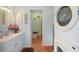 Charming bathroom featuring a vanity, round mirror, with a washer and dryer, offering convenience and style at 1796 Boca Raton Ct, Punta Gorda, FL 33950