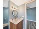 Bathroom featuring a wooden vanity with a white countertop and a round mirror at 1796 Boca Raton Ct, Punta Gorda, FL 33950