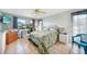 Serene bedroom with a floral-patterned bedspread, a ceiling fan, and a dedicated workspace area at 1796 Boca Raton Ct, Punta Gorda, FL 33950