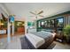 Nicely staged bedroom with ensuite bathroom featuring king bed, ceiling fan, and large window with a view at 1796 Boca Raton Ct, Punta Gorda, FL 33950