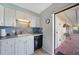 Bright kitchen with white cabinets and black appliances, leading to an outdoor area, offers a seamless indoor-outdoor transition at 1796 Boca Raton Ct, Punta Gorda, FL 33950