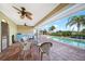 Spacious covered patio with ceiling fans offers serene views of the pool and lush landscaping for ultimate relaxation at 1796 Boca Raton Ct, Punta Gorda, FL 33950