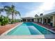Inviting in-ground pool surrounded by brick patio, covered porch, and lush tropical landscaping at 1796 Boca Raton Ct, Punta Gorda, FL 33950