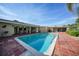 Backyard swimming pool with brick patio, nearby shade, and lush landscaping at 1796 Boca Raton Ct, Punta Gorda, FL 33950