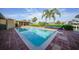 Clean in-ground pool features brick patio, lush landscaping, and water views at 1796 Boca Raton Ct, Punta Gorda, FL 33950