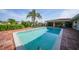 Beautiful backyard pool featuring lush landscaping, brick surround, and waterfront views at 1796 Boca Raton Ct, Punta Gorda, FL 33950