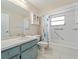 Bathroom with a blue vanity and shower-tub combination with floral curtain at 18151 Cochran Blvd, Port Charlotte, FL 33948