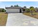Charming single-story home featuring a well-manicured lawn and a spacious driveway leading to the garage at 18151 Cochran Blvd, Port Charlotte, FL 33948