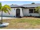 Well-maintained home with a manicured front lawn, tropical landscaping, and a charming arched doorway at 18151 Cochran Blvd, Port Charlotte, FL 33948