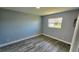 This is a small gray bedroom with wood floors and a single window at 18519 Alphonse Cir, Port Charlotte, FL 33948