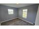 This is a small bedroom with gray walls, white trim and two windows at 18519 Alphonse Cir, Port Charlotte, FL 33948