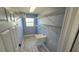 Well-organized laundry room features a utility sink, wire shelving, and natural light from the window at 18519 Alphonse Cir, Port Charlotte, FL 33948