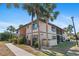 Multi-Gathering home with lush landscaping featuring mature palm trees under a clear blue sky on a sunny day at 19505 Quesada Ave # Pp201, Port Charlotte, FL 33948