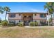 Exterior of building is neatly maintained with mature landscaping and ample parking at 19505 Quesada Ave # Pp201, Port Charlotte, FL 33948