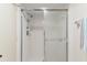 Enclosed glass shower with silver hardware and towel rack in a pristine, all-white bathroom at 19505 Quesada Ave # Pp201, Port Charlotte, FL 33948