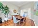Light-filled dining room with hardwood floors, modern buffet, and decorative plants at 196 Tarpon Cove Blvd # 722, Punta Gorda, FL 33950