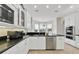 Well-lit kitchen features white cabinetry, black countertops, and a stainless steel dishwasher at 196 Tarpon Cove Blvd # 722, Punta Gorda, FL 33950