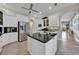 This kitchen includes stainless steel refrigerator, kitchen island, and white cabinetry at 196 Tarpon Cove Blvd # 722, Punta Gorda, FL 33950