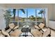 Screened-in lanai with wicker furniture and tranquil views of the tropical landscape and waterfront at 196 Tarpon Cove Blvd # 722, Punta Gorda, FL 33950