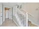 Bright staircase features carpeted steps, a white banister, and tiled floors at 196 Tarpon Cove Blvd # 722, Punta Gorda, FL 33950
