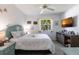 Cozy bedroom with a ceiling fan, TV, and window overlooking the yard at 25179 Campos Dr, Punta Gorda, FL 33983