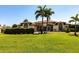 Beautiful single-story home with arched entryway, meticulously maintained lawn, and tropical palm trees at 25179 Campos Dr, Punta Gorda, FL 33983