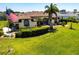 Charming home with manicured lawn, palm trees, and American flag waving in the front yard at 25179 Campos Dr, Punta Gorda, FL 33983